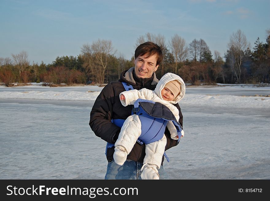 Father and baby in a carrier having a good time on winter weekend