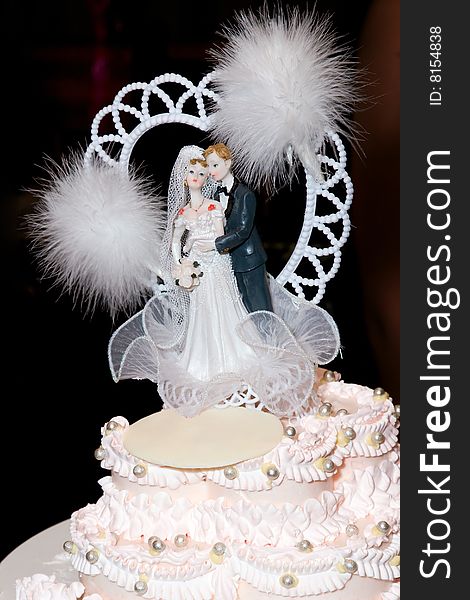 Figurine of a groom and a bride decorated higher part of the wedding cake. Figurine of a groom and a bride decorated higher part of the wedding cake.