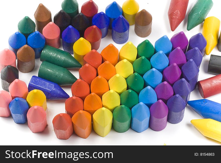 Rainbow stacked wax crayons on colored background