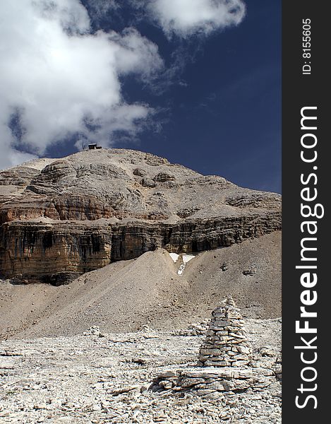 Piz Boe, a white dolomite peak with a cabin on top and a stone man on foreground