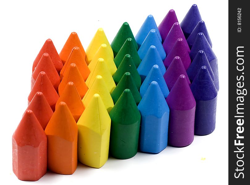 Rainbow stacked wax crayons on white background