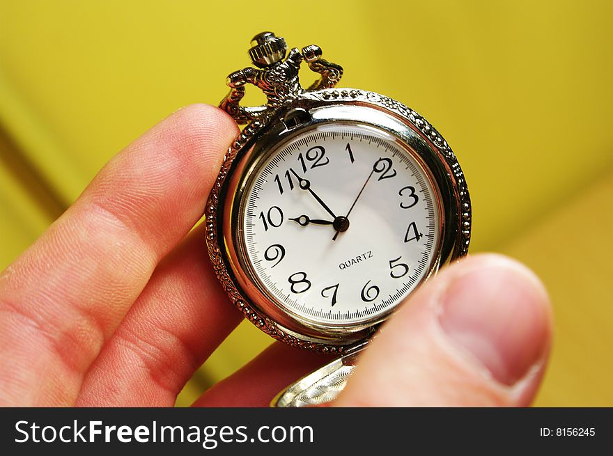 Hand holds a beautiful vintage silver pocket watch