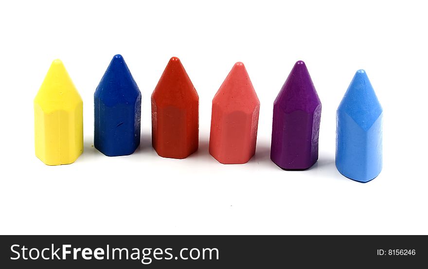 Six wax crayons several colors on white background