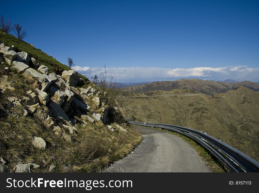 Sharp curve in a mountain road with mountains in background