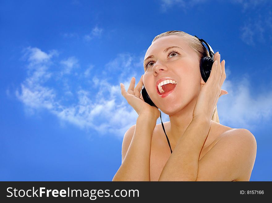 Portrait of happiness young women with beautiful face in headphones and listening music on the sky background. Portrait of happiness young women with beautiful face in headphones and listening music on the sky background