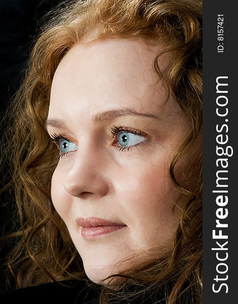 Portrait of a beautiful blue eyed woman on black background