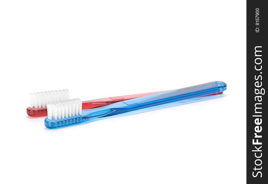 A blue and a red toothbrush isolated on white background. A blue and a red toothbrush isolated on white background.