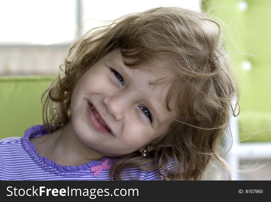 Little Girl Smiling at Camera with chairs in the background