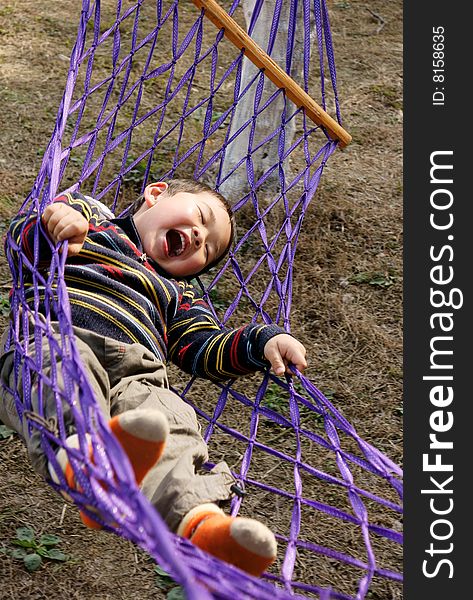 A picture of a little chinese boy laughing and having great fun in hammock. A picture of a little chinese boy laughing and having great fun in hammock