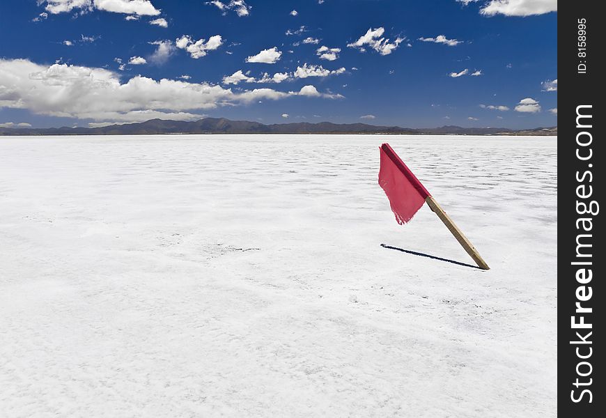 A red flag stuck in a huge salt field. A red flag stuck in a huge salt field.