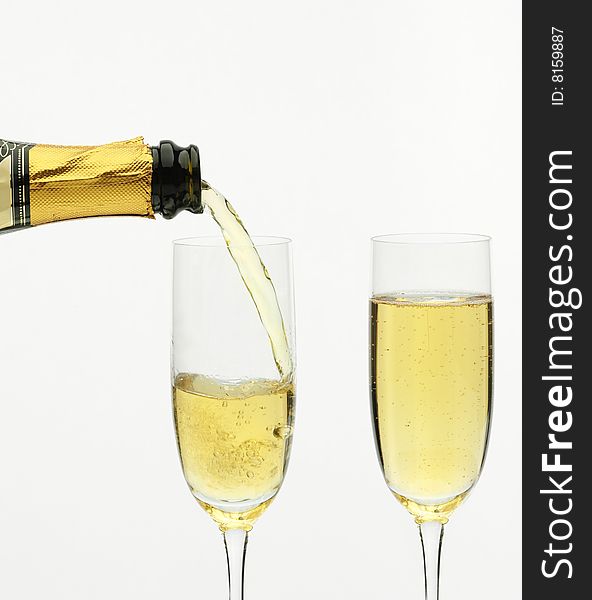 Champagne being poured into a flute, isolated on a white background. Champagne being poured into a flute, isolated on a white background.