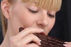 Beautiful Blond Girl Eating Chocolate Close Up Stock Photos