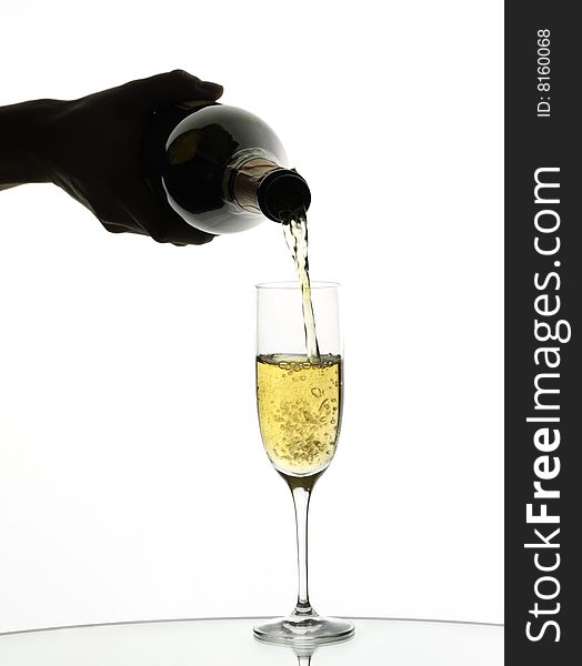 Champagne being poured into a flute, isolated on a white background.
