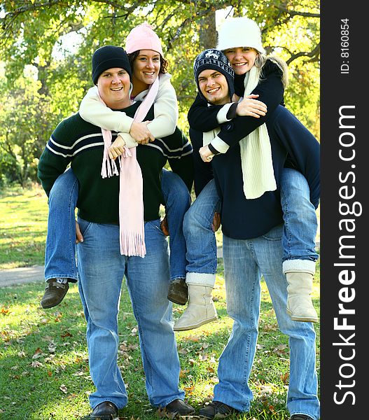 Two couple piggyback each other and walking on the park. Two couple piggyback each other and walking on the park