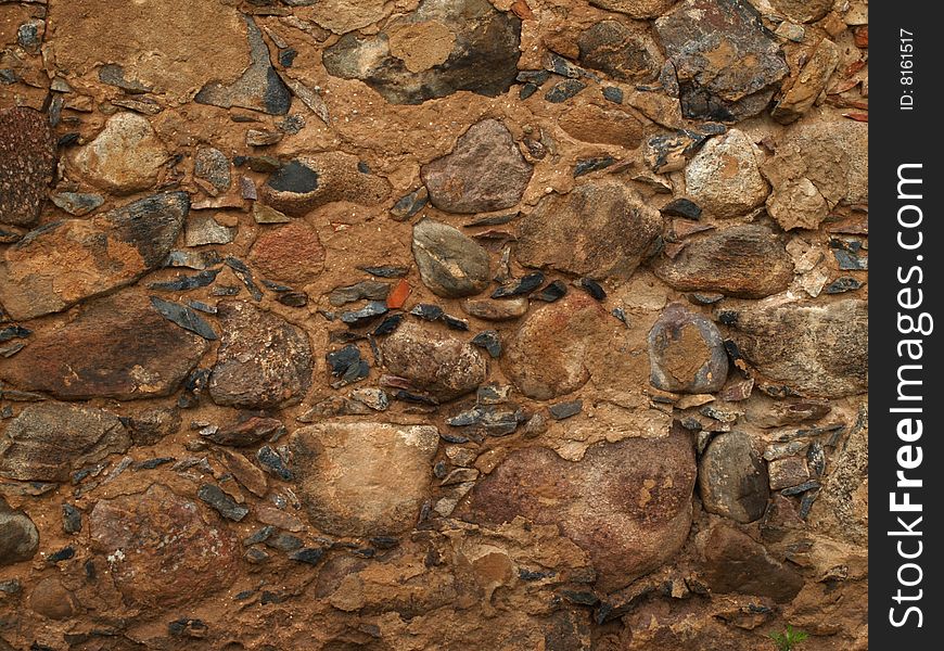 Wet stony wall with different size rocks