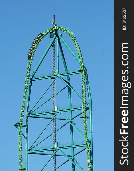 A metal roller coaster against blue sky