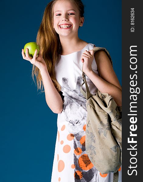 Young cute schoolgirl posing with an apple. Young cute schoolgirl posing with an apple