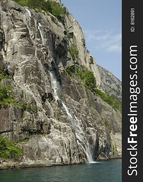 A waterfall flowing into the sea in Norway. A waterfall flowing into the sea in Norway