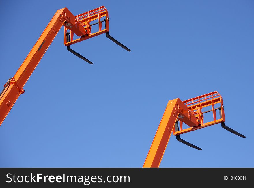 Orange Forklifts Under a Vivid Blue Sky