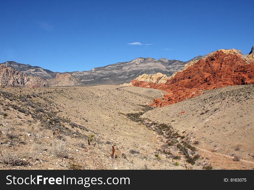 Brown and red desert landscape under a vivid blue sky