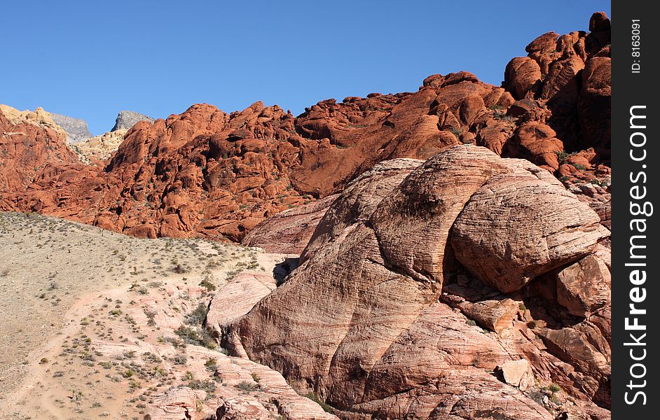 Brown and red desert landscape under a vivid blue sky