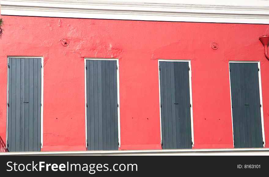 Red building with green shutters, in horizontal orientation