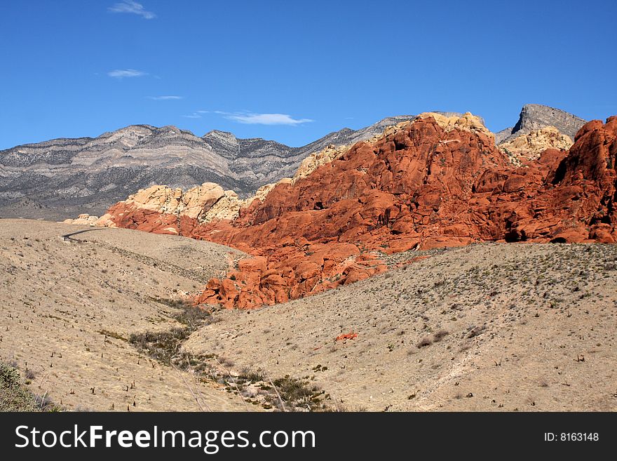 Brown and red desert landscape under a vivid blue sky