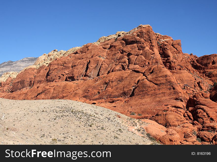 Brown and red desert landscape under a vivid blue sky