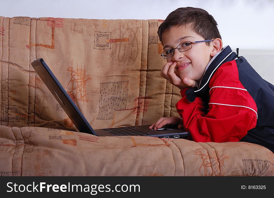 A teenager playing computer game on lap top in the living room. A teenager playing computer game on lap top in the living room.