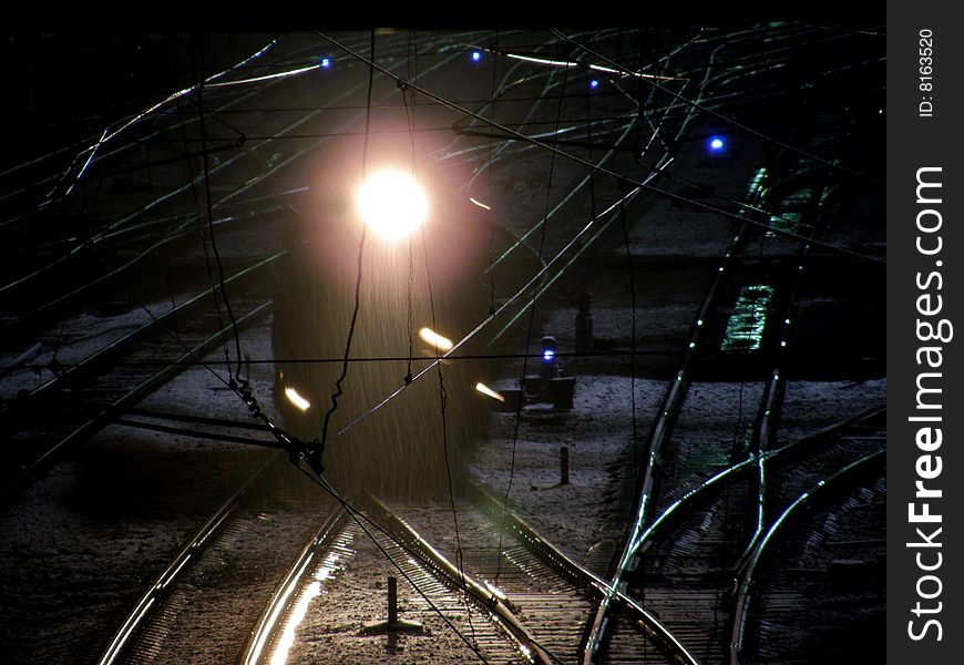 The locomotive on the rail crossing at night. The locomotive on the rail crossing at night