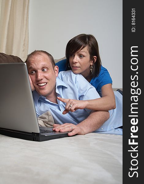 Young couple on the couch at home looking at the laptop!. Young couple on the couch at home looking at the laptop!