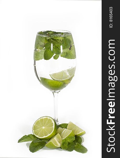 Glass with cocktail, limes with mint leaves, isolated on white background