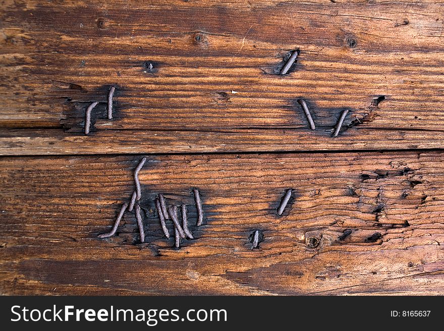 Stock photo: an image of a background of brown wood with nails in it. Stock photo: an image of a background of brown wood with nails in it
