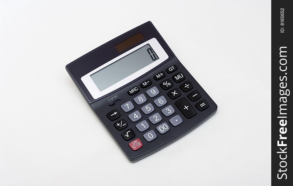 An electronic calculator on grey. An electronic calculator on grey