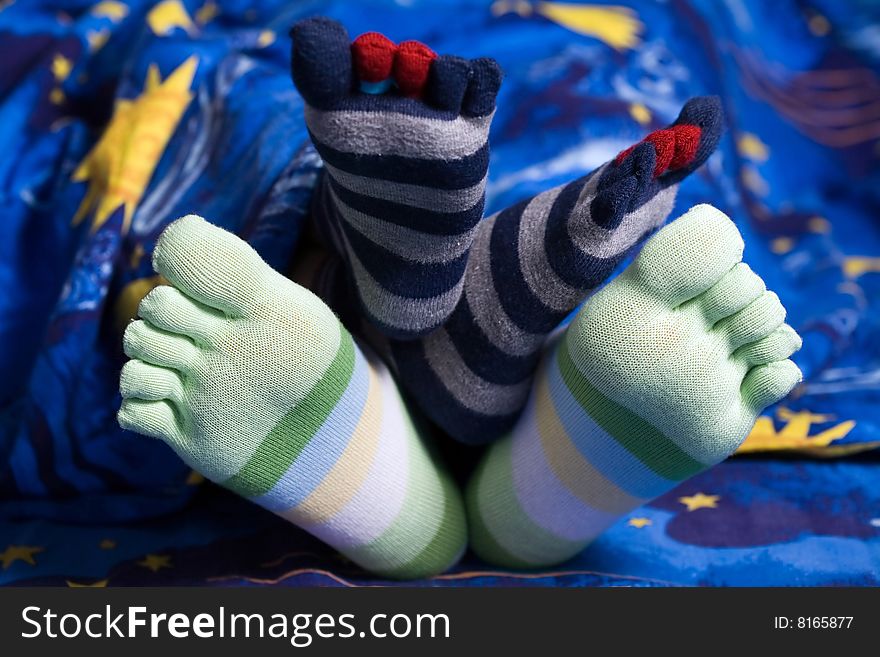 Stock photo: an image of two pairs of funny feet in striped socks