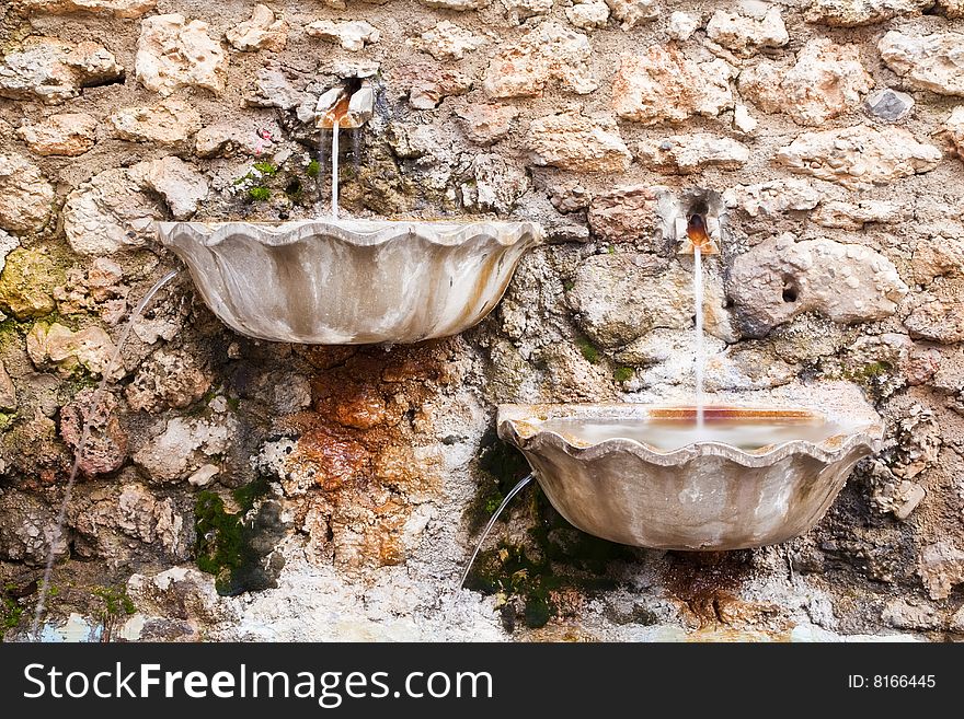 Long exposed waterfountains in an old stonewall