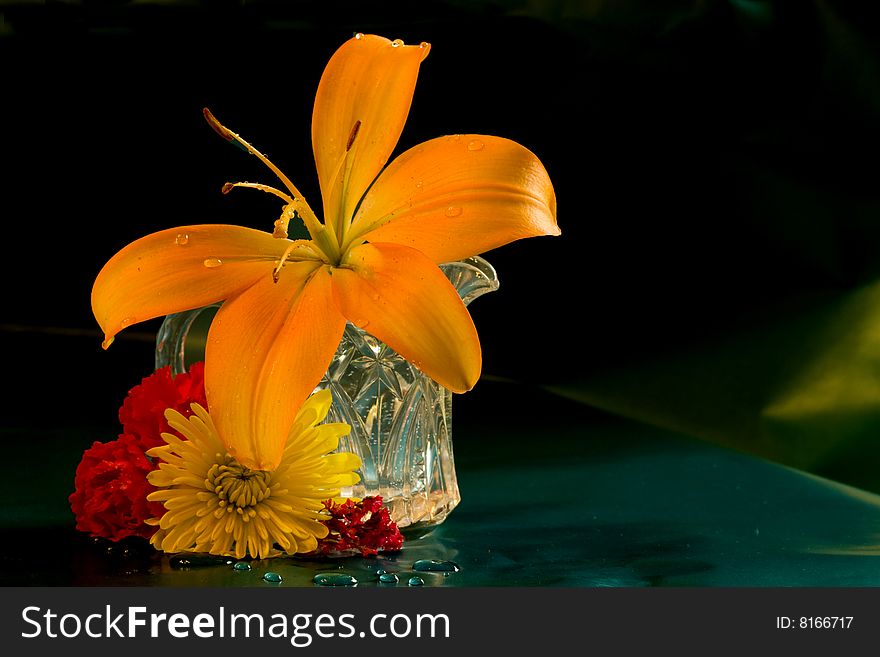 Day lilly along with a few carnations and a yellow mum in small pitcher. Day lilly along with a few carnations and a yellow mum in small pitcher.