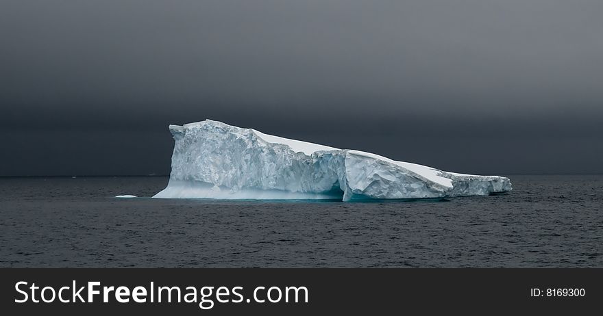 A tabular iceberg slanting into the sea in Antarctica. A tabular iceberg slanting into the sea in Antarctica.