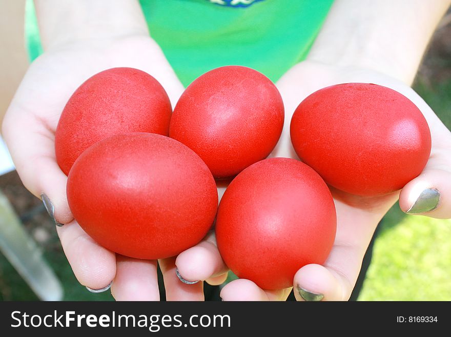 Easter red eggs on the hands.