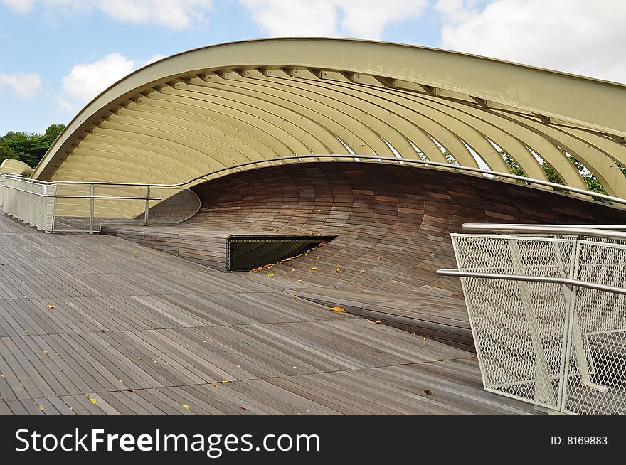 An unique design of a shelter and rest stop along a wooden walkway.