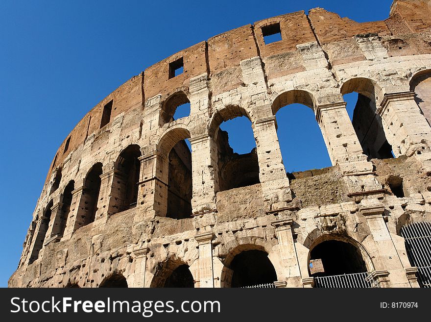 The massive Roman Colosseum in a bright sunny late winter morning. The massive Roman Colosseum in a bright sunny late winter morning