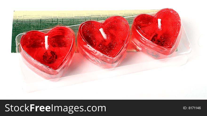 Row of red heart candles isolated over white