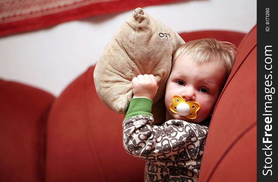 Small baby girl makes fun on sofa