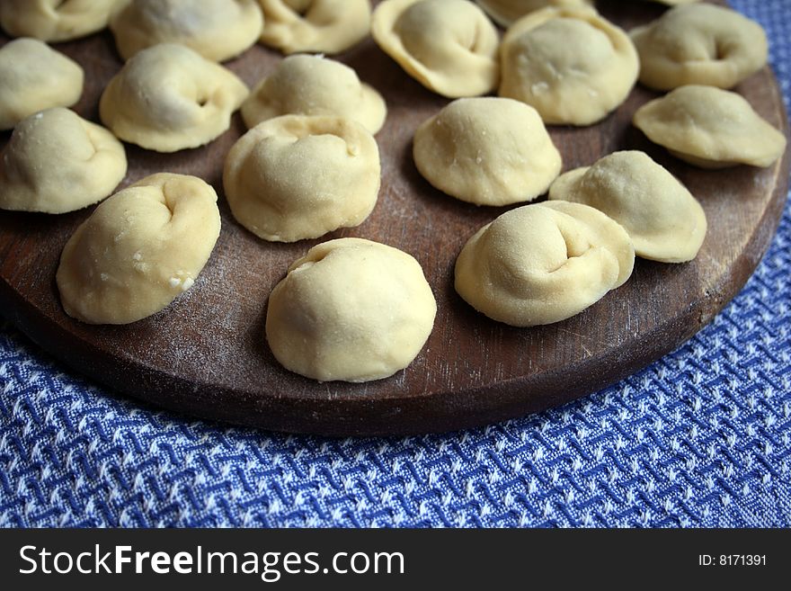 Pel'menis or raviolli with meat - a dish characteristic for the Italian, Russian, Ukrainian and Chinese kitchen. In this picture - the home  made Russian pel'menis.