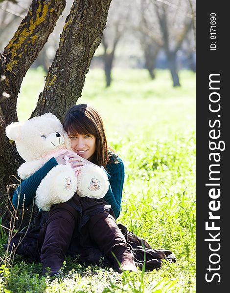 Young smiling woman embracing a teddy bear. Young smiling woman embracing a teddy bear