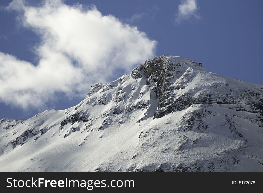 A snow covered mountain and blkue sky in the French Alps