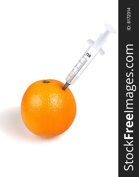 Syringe inserted into an orange. Syringe inserted into an orange