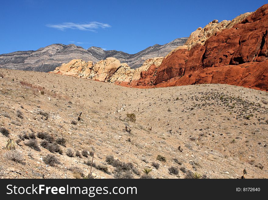 Brown and red desert landscape under a vivid blue sky