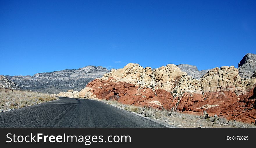 A Stretch of Blacktop Highway in a Colorful Desert. A Stretch of Blacktop Highway in a Colorful Desert