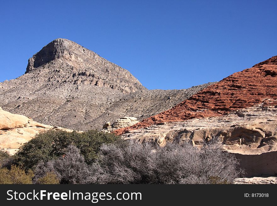 Brown and red desert landscape under a vivid blue sky